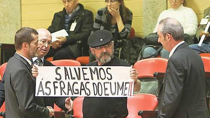 Un representante de la Plataforma en Defensa das Fragas do Eume saca una pancarta durante el pleno de ayer.  // Xoán Álvarez