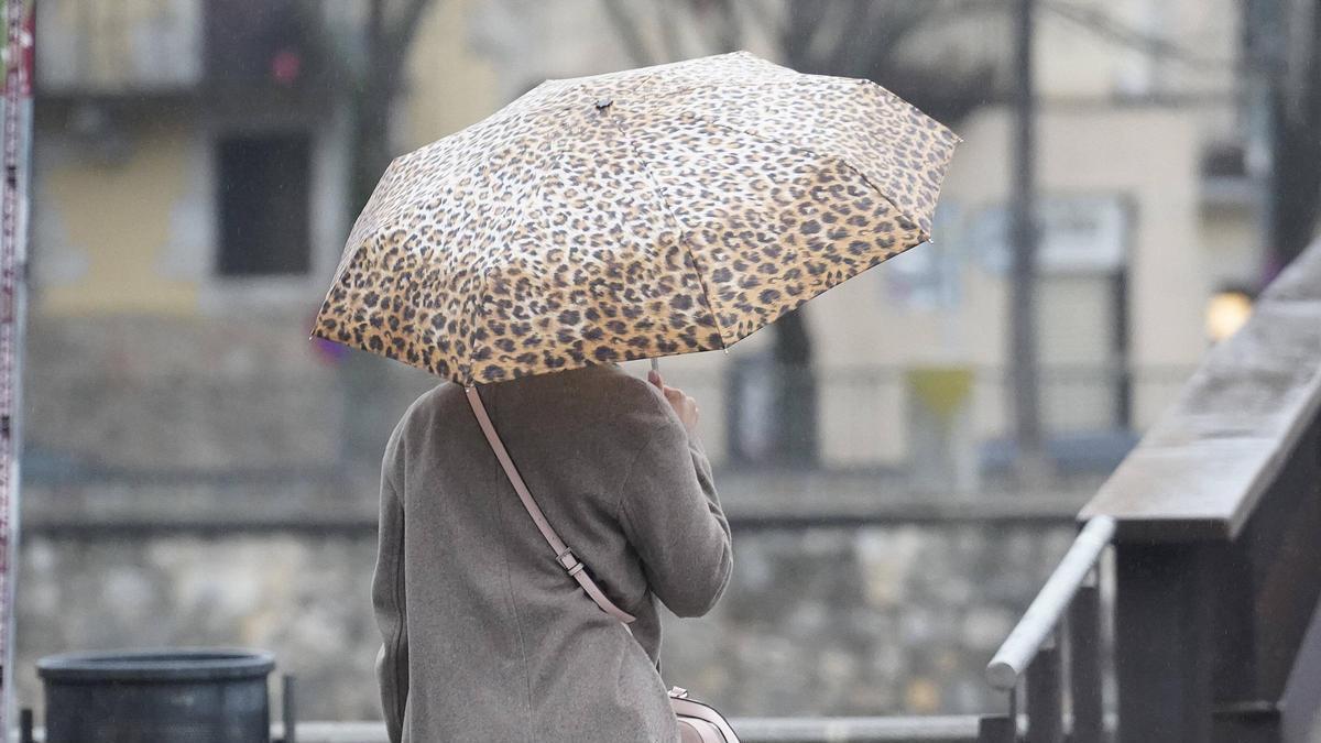 Una persona portant un paraigües a Girona