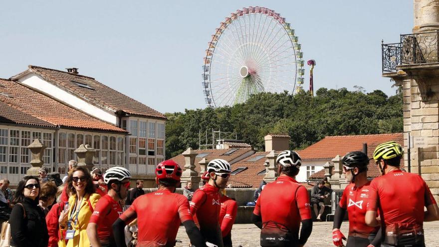 Un grupo de ciclistas descansa en la Praza do Obradoiro, con la noria al fondo / antonio hernández