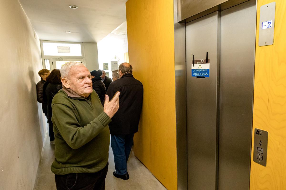 Un inquilino enseña el ascensor clausurado desde primeros de diciembre y que no les reparan.
