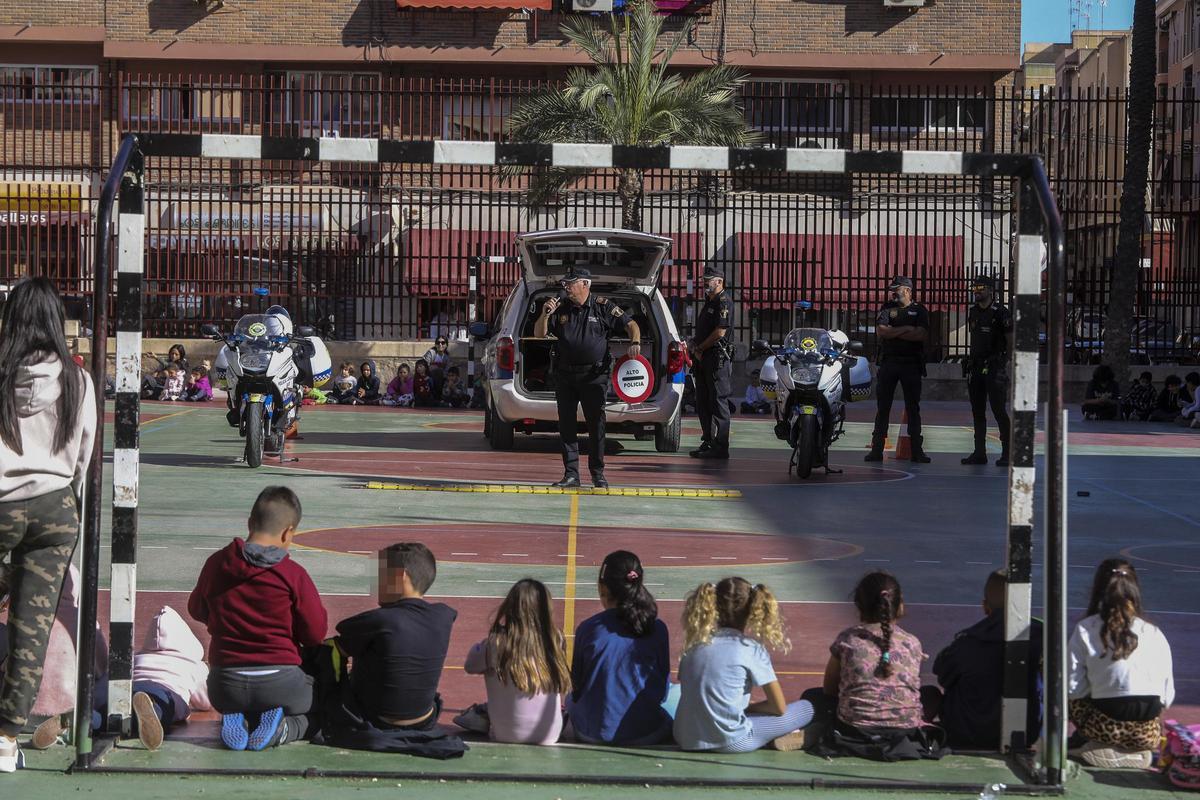 Niños en el patio escuchan las explicaciones de los policías locales de Elche