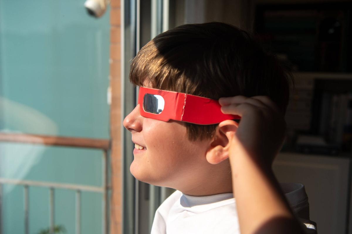 Mateo probando las gafas especiales para ver el eclipse del 12 de agosto. Sociedad. Barcelona, 7 de agosto de 2026. Foto: Belén González / EP