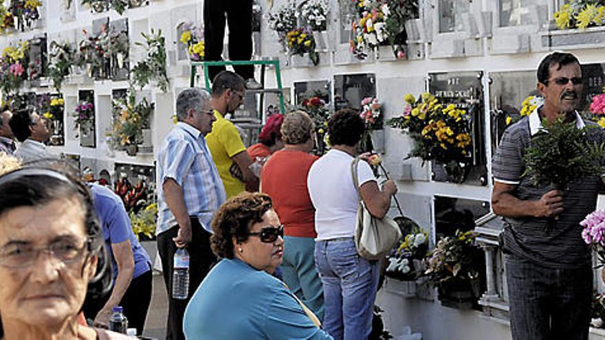 Ciudadanos, ayer, colocando flores en el cementerio de San Román, en Arrecife.  JAVIER FUENTES