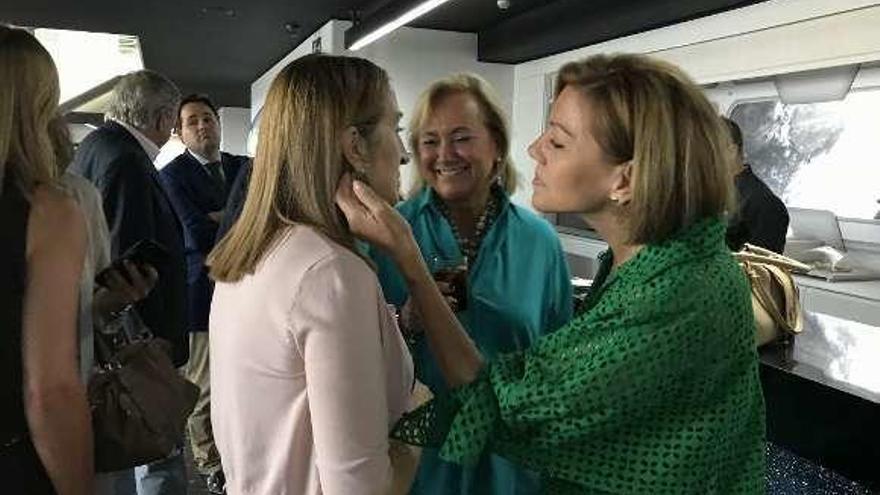 Dolores de Cospedal admira los pendientes de Ana Pastor ante Mercedes Fernández, ayer, antes del comité ejecutivo.
