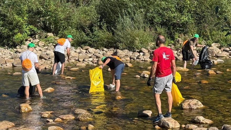 Medio centenar de peñistas limpian el río Nalón tras el Descenso Folklórico: "Hoy es cuando acaba la fiesta de verdad"
