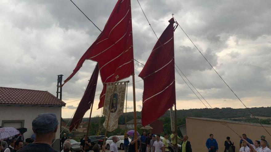 1. El inicio de la procesión con varios pendones desplegados. 2. Celebración de la misa con los pendones dispuestos en el templo. 3. Las imágenes preparadas para la procesión. 4. Un grupo de mujeres de la Cofradía de Santa Bárbara ataviadas con trajes típicos. 5. Varias personas recogiendo uno de los pendones por la lluvia. 6. Varios pendoneros colaborando para mover un pendón. 7 Preparativos de la procesión. | E. P.