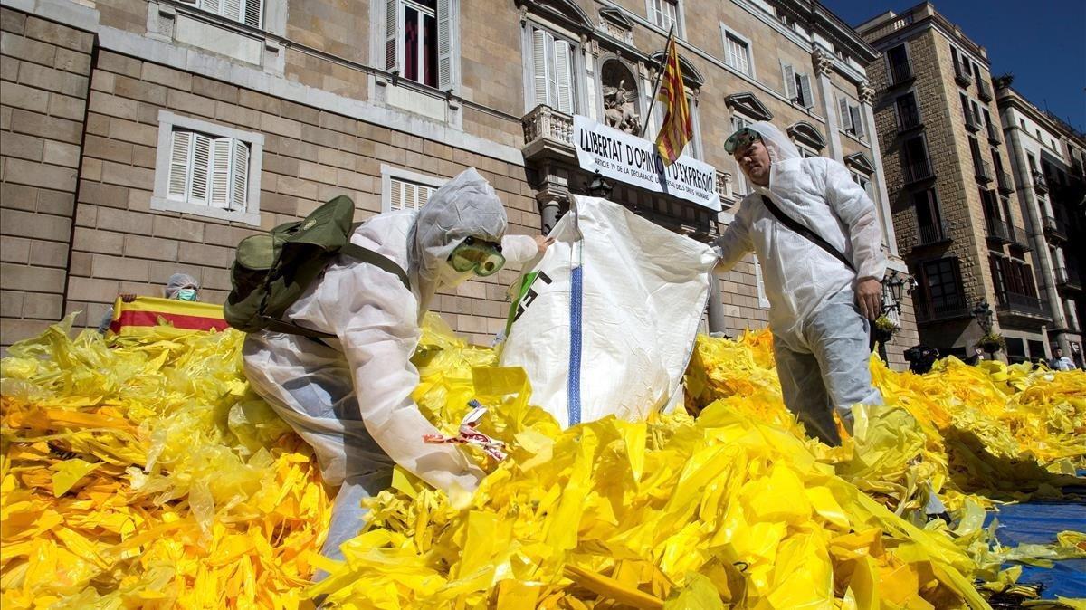 Miembros de la brigada de limpieza Els Segadors del Maresme  que se dedican a quitar lazos amarillos de lugares publicos  los depositan frente a la fachada principal del Palau de la Generalitat.