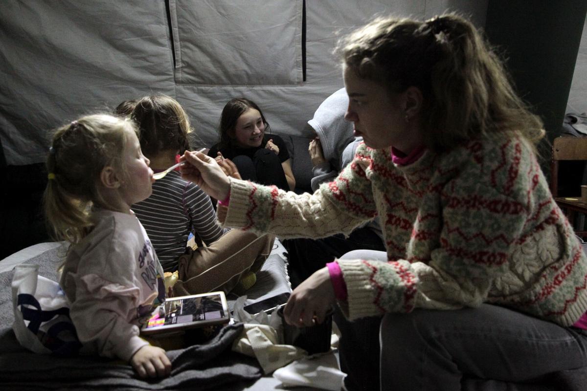 Una chica alimenta a una niña en una de las carpas colocadas en el distrito de Desnianskyi de Kiev.