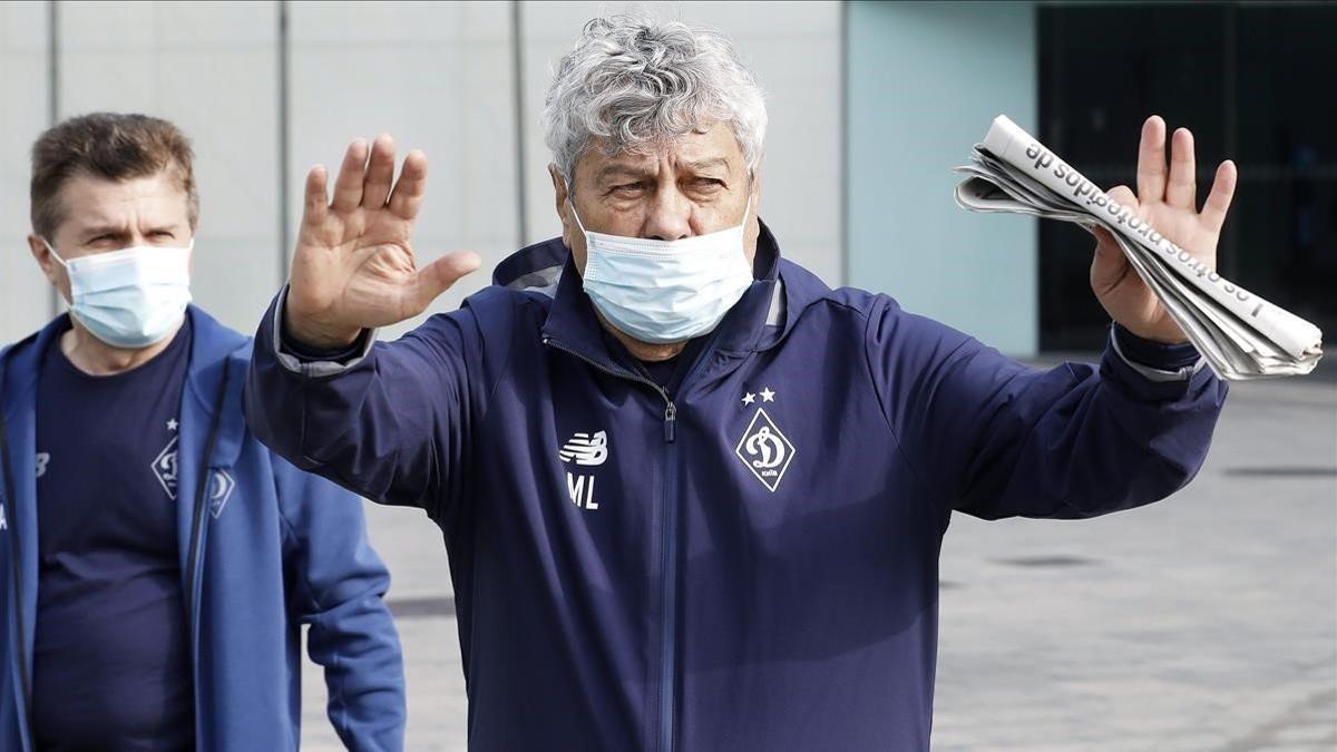 Mircea Lucescu sale del hotel de Barcelona donde se hospeda el Dinamo de Kiev con un ayudante suyo.