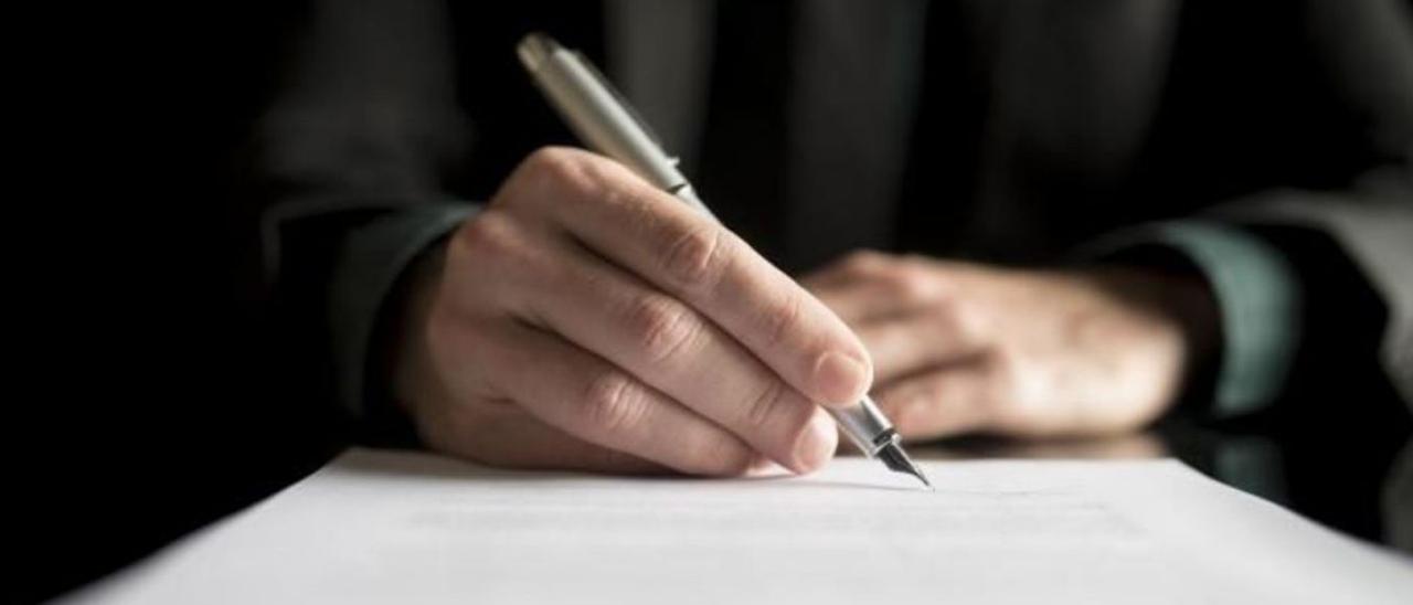 Un hombre firma un testamento en una foto de archivo. | LEVANTE-EMV