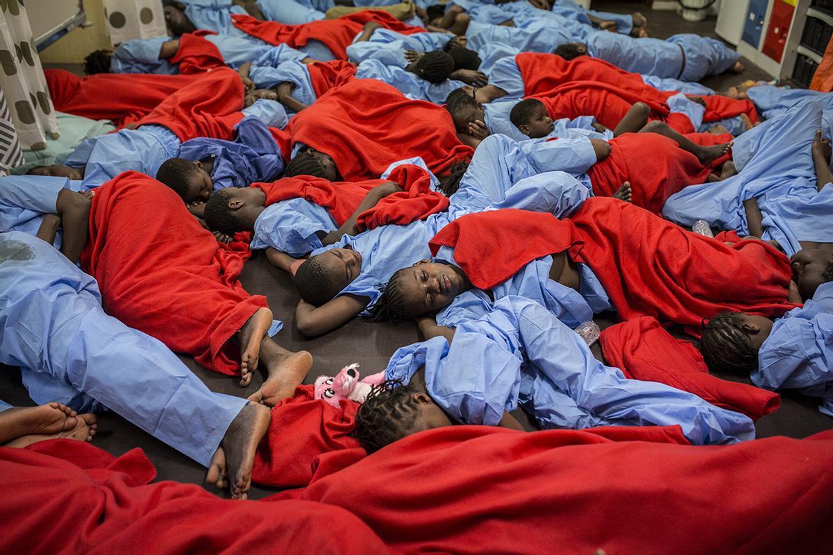 Mujeres y niños descansan en la bodega del barco Golfo Azurro después de haber sido rescatados por Open Arms en enero de 2017.