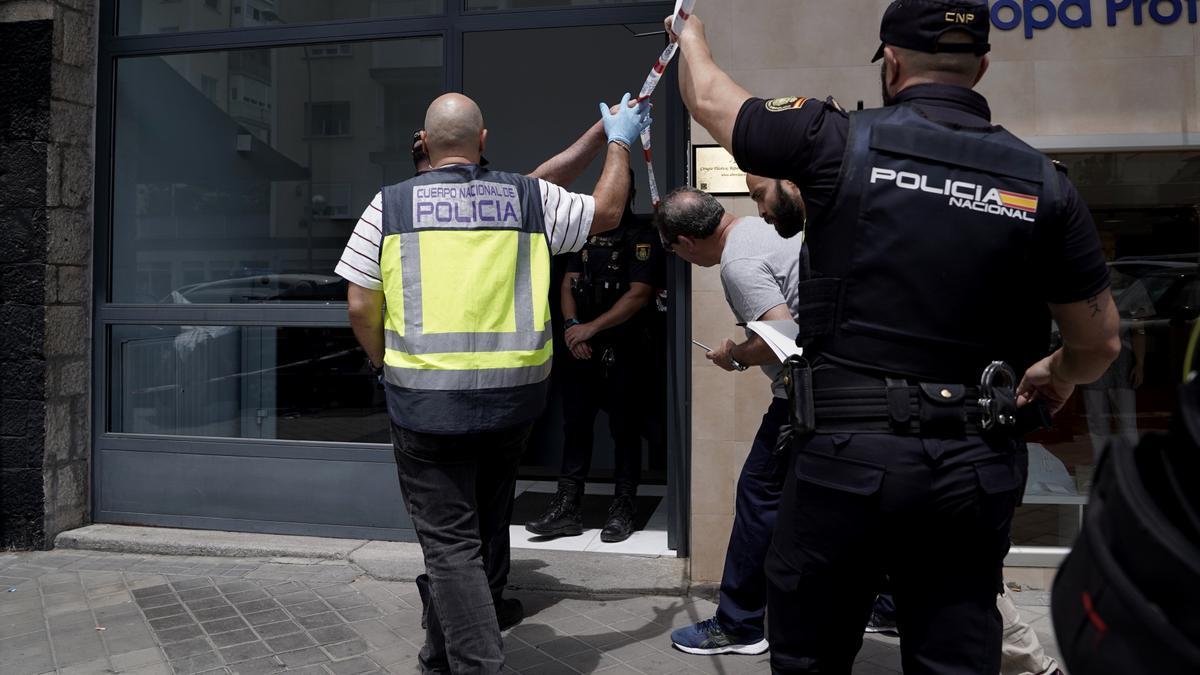 Los Policías entran en el portal donde han aparecido tres muertos por disparos en Madrid.