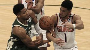 Antetokounmpo (izda.), pelea por una pelota con Booker.