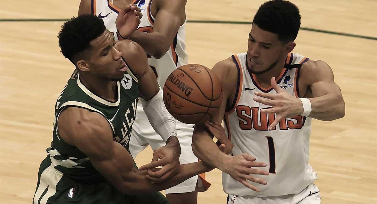 Antetokounmpo (izda.), pelea por una pelota con Booker.
