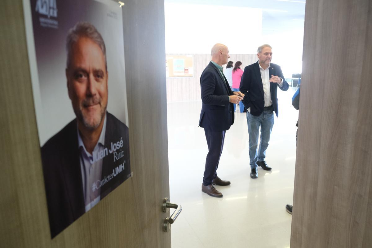 Un cartel de la candidatura de Juan José Ruiz cuelga de la puerta del aula donde el rector, al que se le ve charlando, presentó su programa electoral.