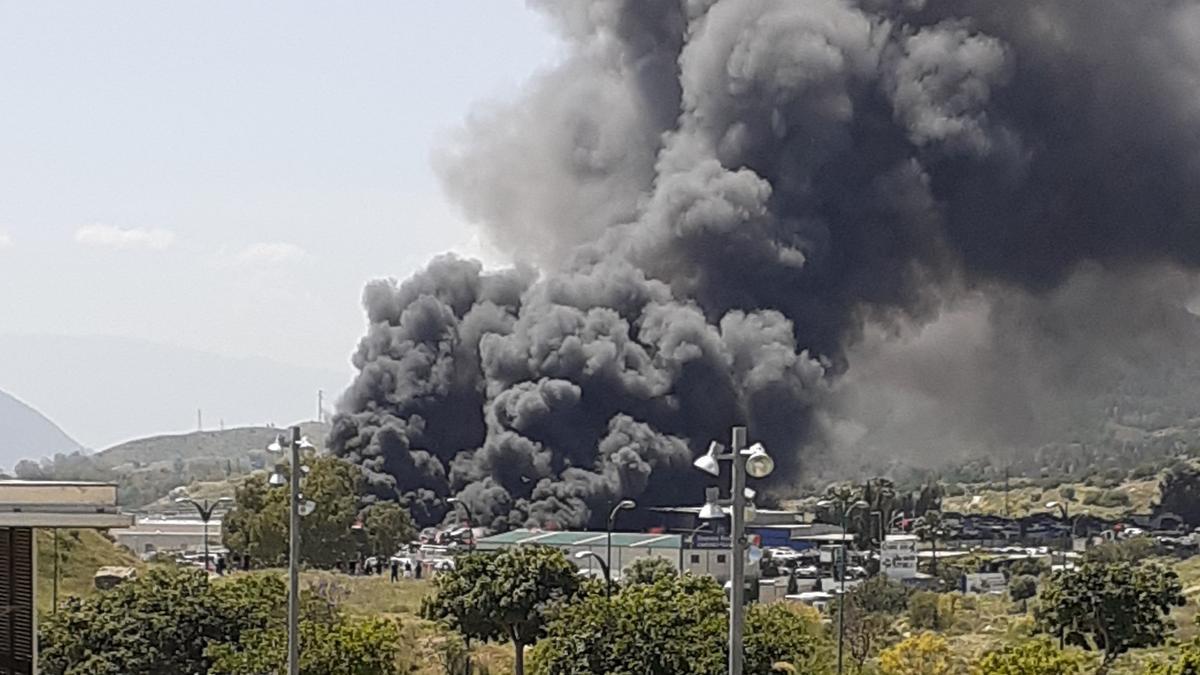 Humareda procedente del incendio declarado este viernes tarde en un desguace de Los Asperones.