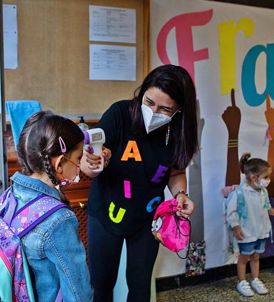 Una profesora toma la temperatura a una escolar al entrar al Amor de Dios.