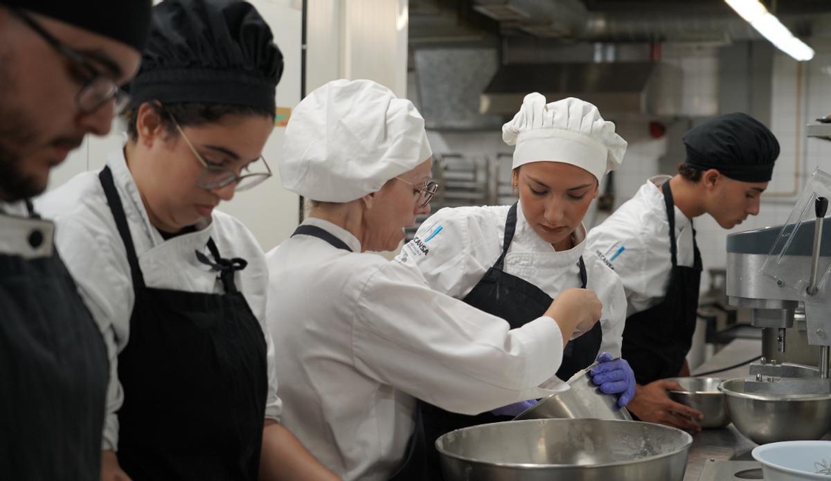 Estudiantes de Hecansa en una práctica en cocina reciben explicaciones de una docente.