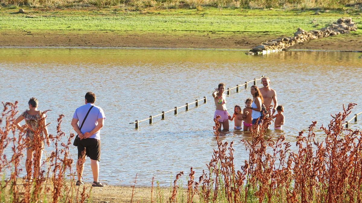 Algunos curiosos acuden al pantano para ver el antiguo puente sobre el Bodión