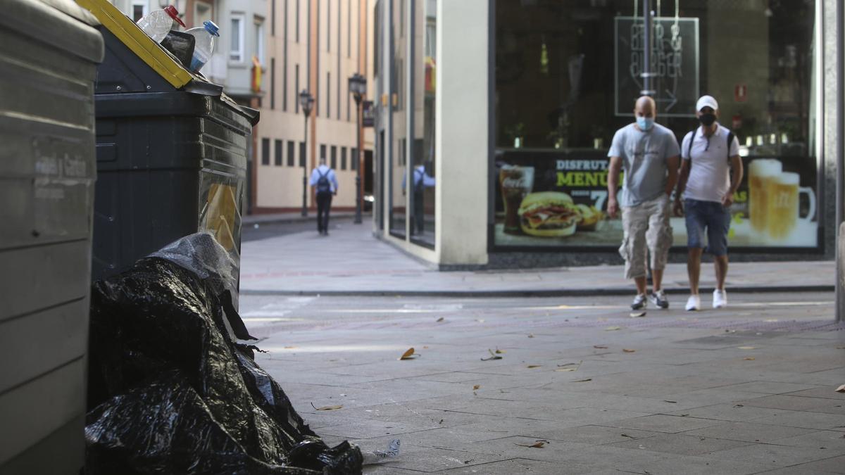 Suciedad en las calles y basura junto a los contenedores en el centro.