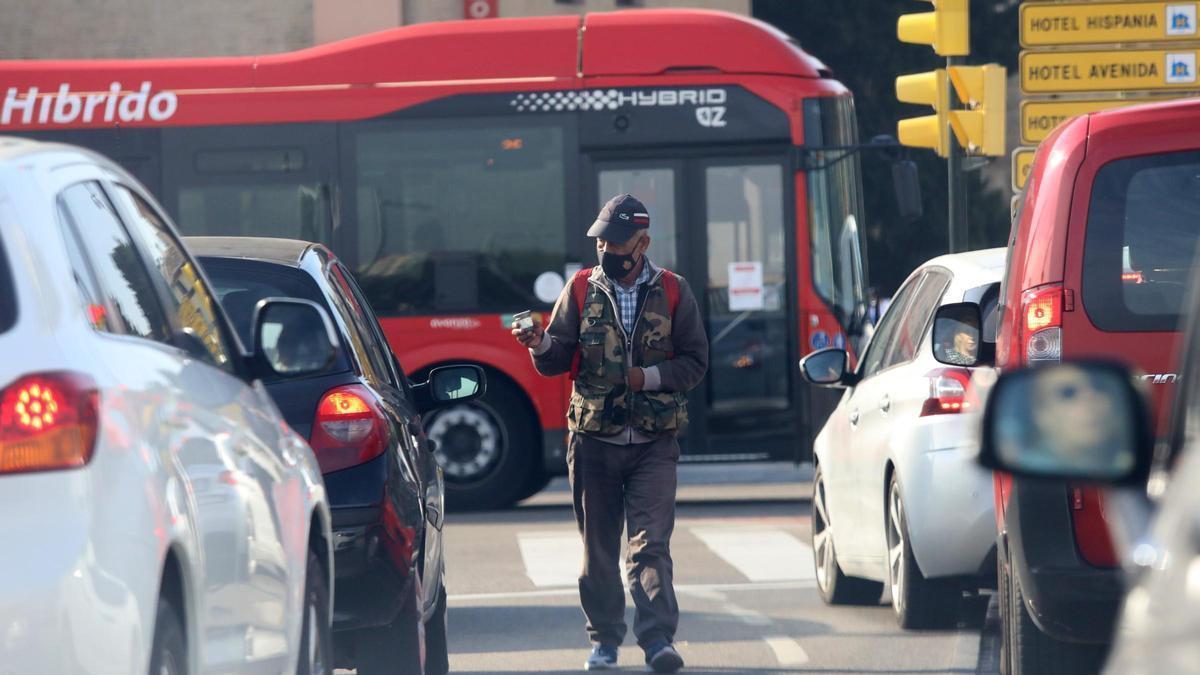 Una persona pide limosna entre los coches de Zaragoza en una imagen de archivo.