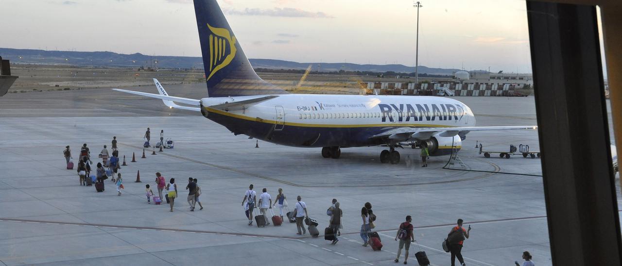 Viajeros en el aeropuerto de Zaragoza dirigiéndose a un avión de la compañía Ryanair.