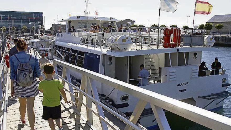 Pasajeros suben a uno de los barcos del transporte de ría. // M. Canosa