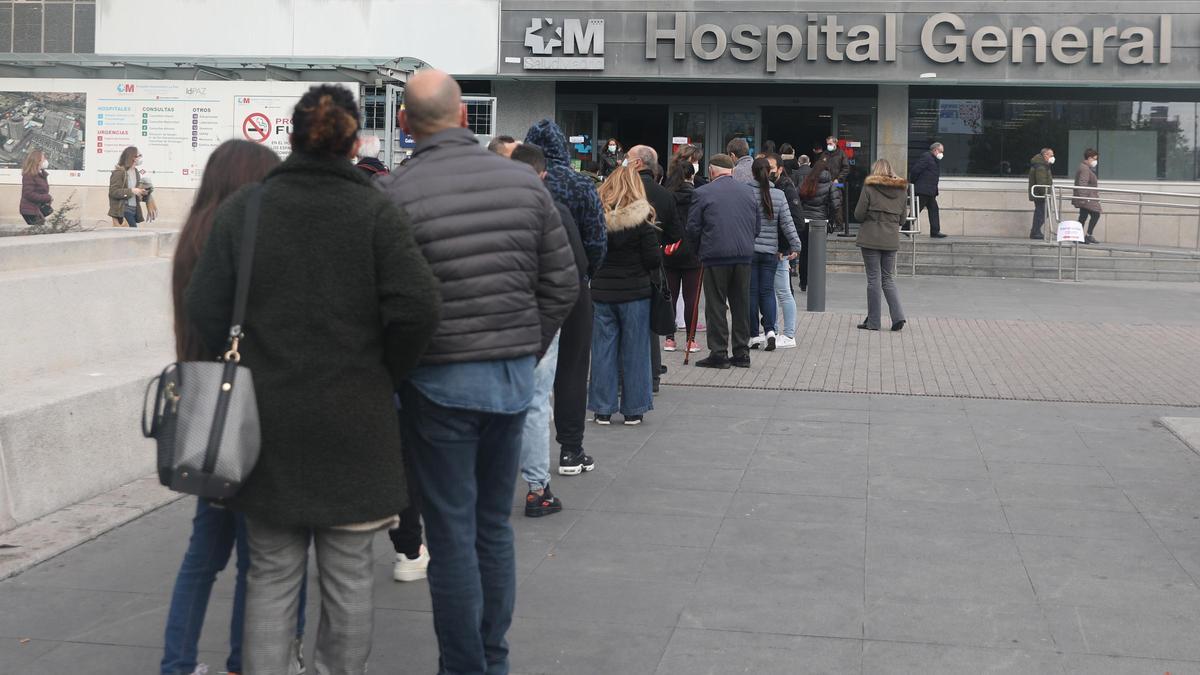 Ciudadanos madrileñós hacen cola para obtener un test de antígenos.