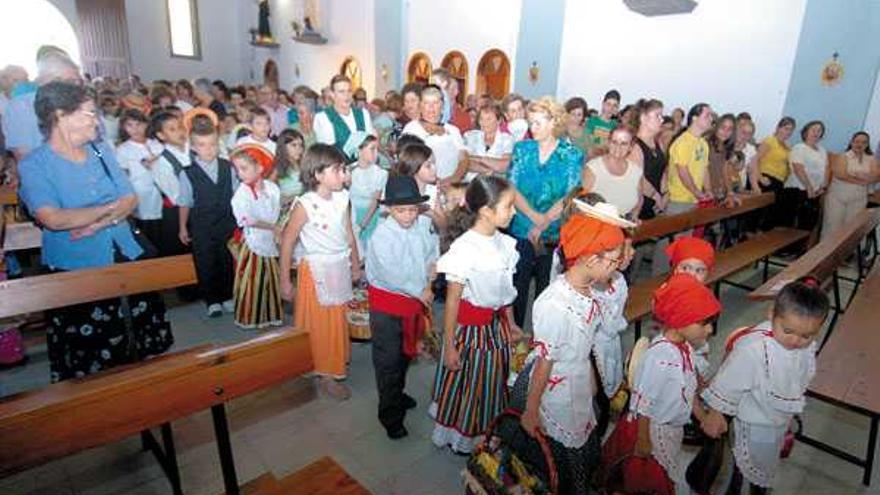 Los niños de Vecindario acercan sus ofrendas a San Rafael.