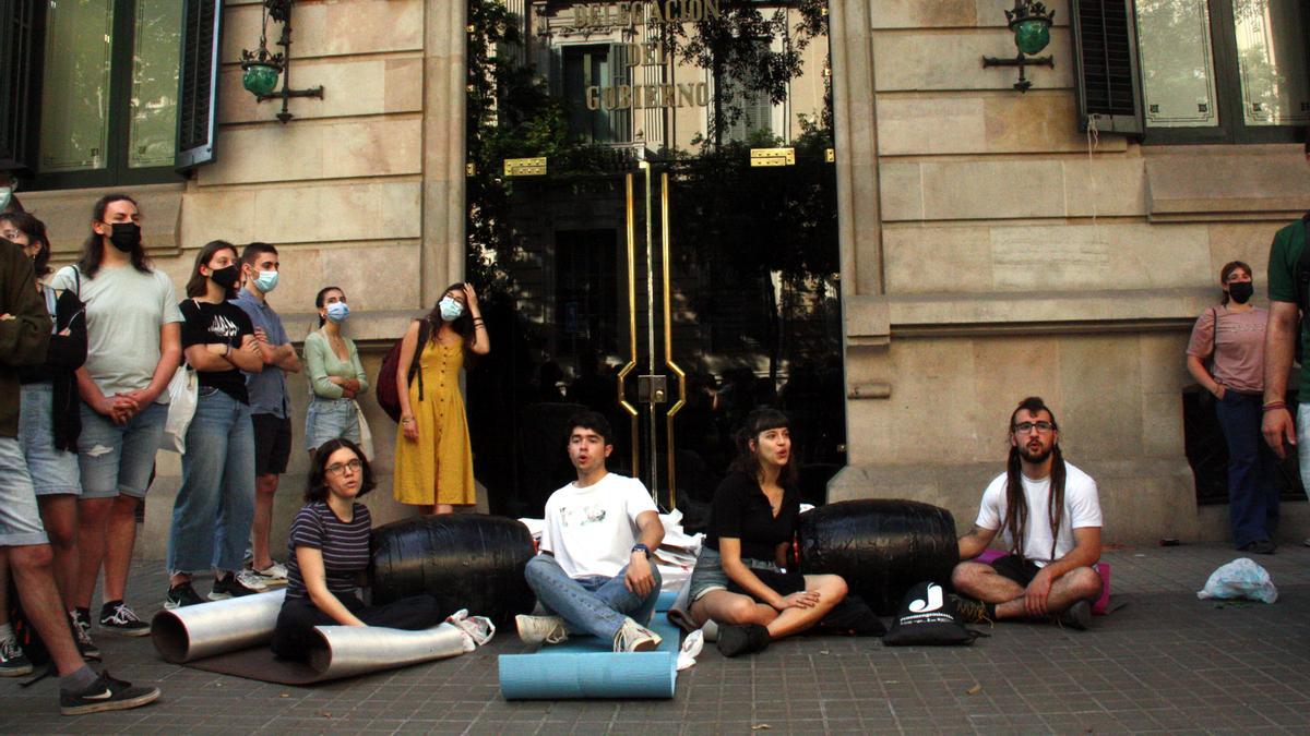 Quatre estudiants asseguts a terra i encadenats davant la Delegació del govern espanyol a Catalunya