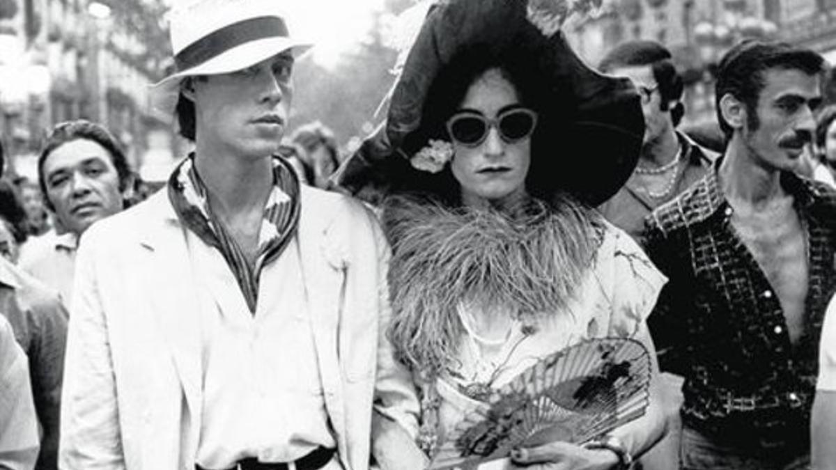 Ocaña, con pamela y vestido, camina por la Rambla cogido de un brazo por Camilo, en la película de Ventura Pons.