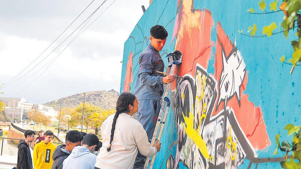 Alumnos del IES Santa Lucía, trabajando en el mural del barrio.