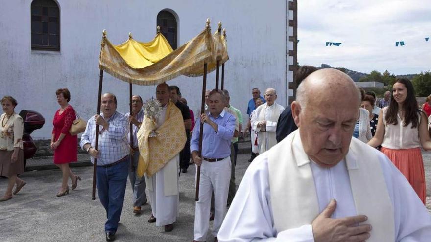 Arriba, procesión alrededor de la iglesia de Vega. A la izquierda, niños con el traje regional .