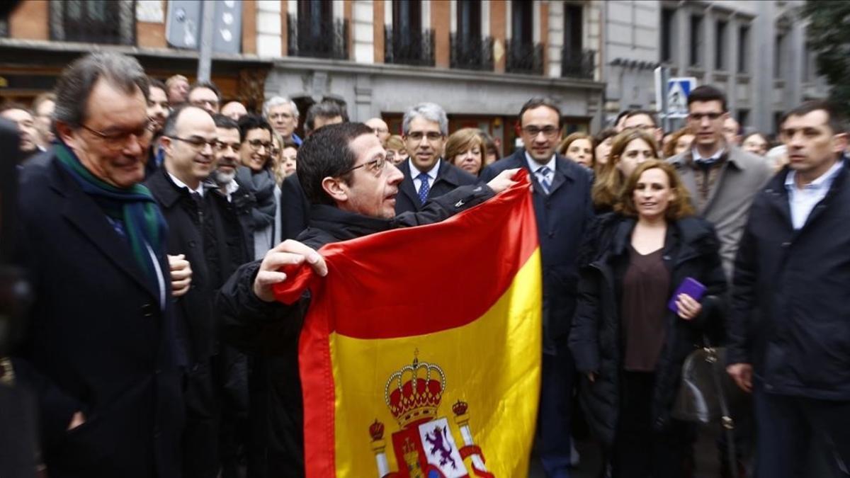 Un hombre muestra una bandera de España en la concentración de apoyo a Homs en Madrid.