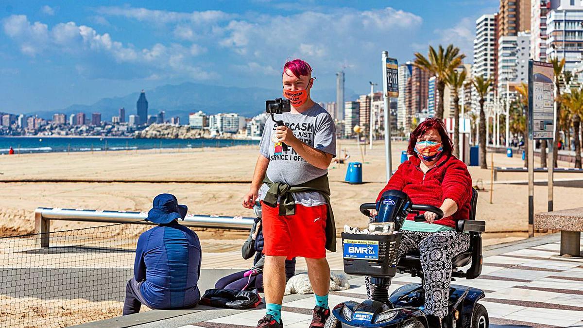 Una pareja de turistas británicos pasea por el paseo de la playa de Levante (Benidorm). | DAVID REVENGA