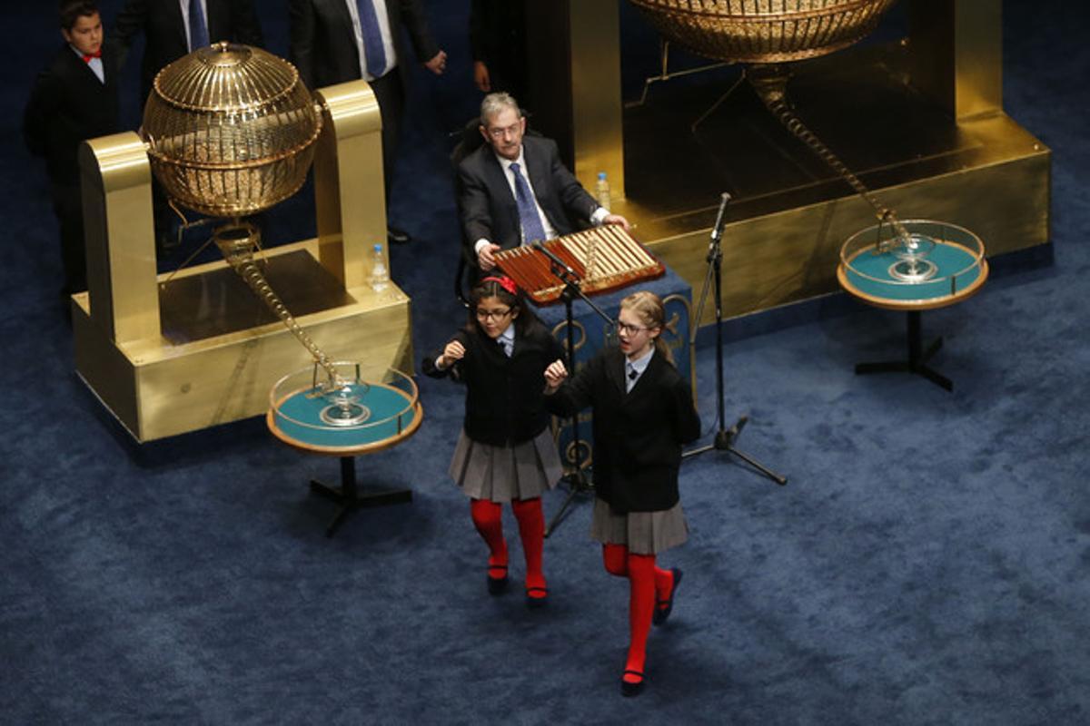 Les nenes de Sant Ildefons que han cantat el Gordo mostren el número premiat.