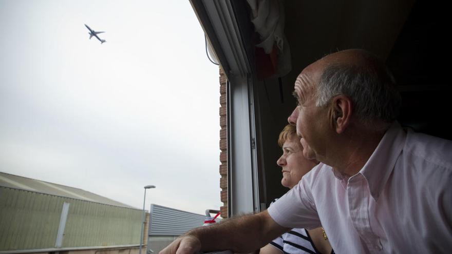 Unos vecinos observan el paso de un avión sobre su vivienda