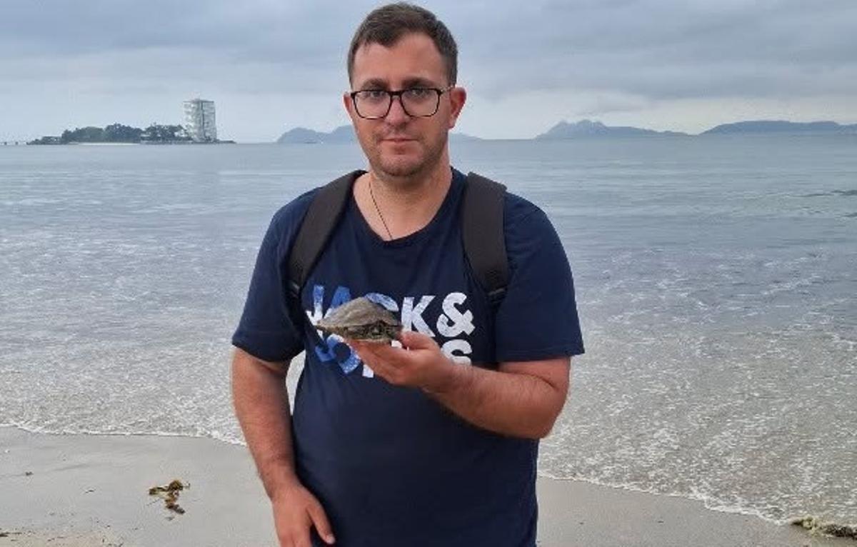 El joven que halló la tortuga la muestra sobre la palma de su mano.