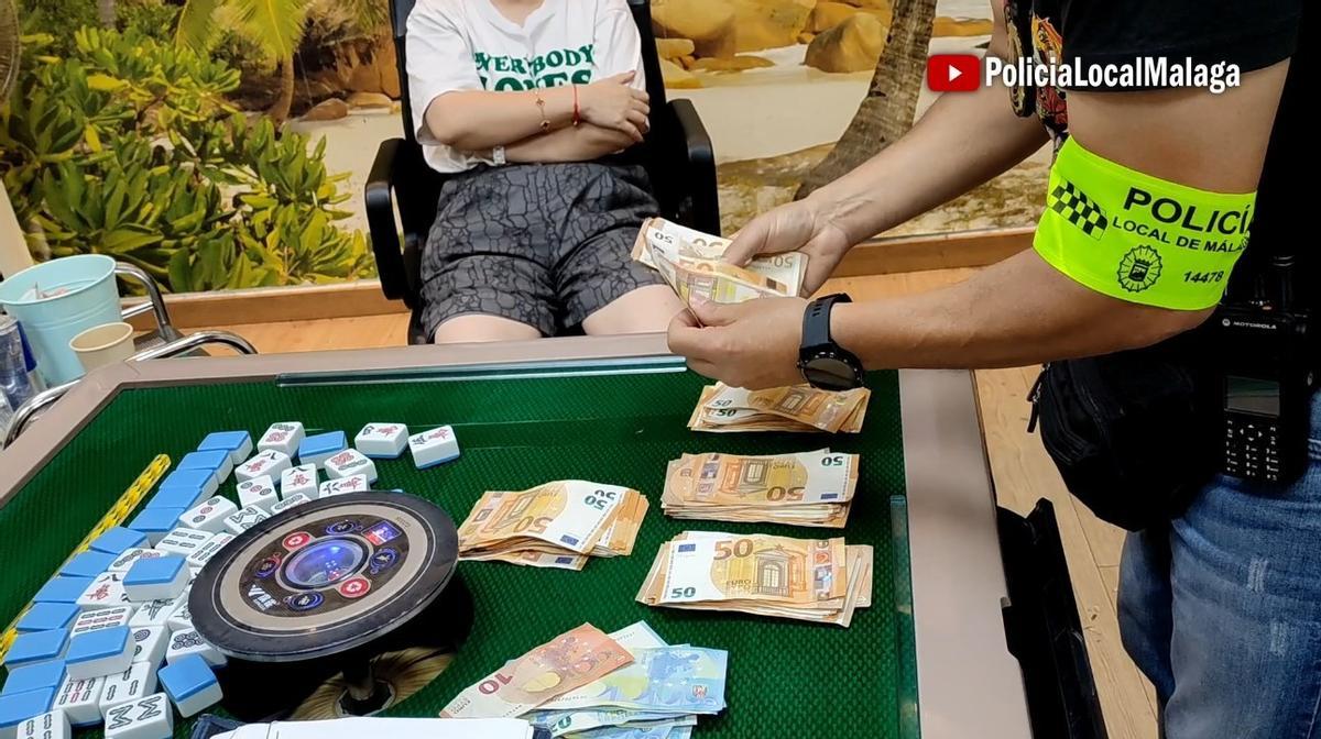 Un agente de la Policía Local contando el dinero intevenido en la mesa de juego