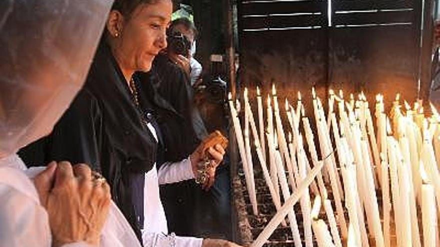 La candidata a la Presidencia de Colombia, Ingrid Betancourt (c), que fue liberada junto a otros 14 rehenes de la guerrilla colombiana de las FARC el pasado día 2, enciende una vela a su llegada a la Gruta de Lourdes (Francia).