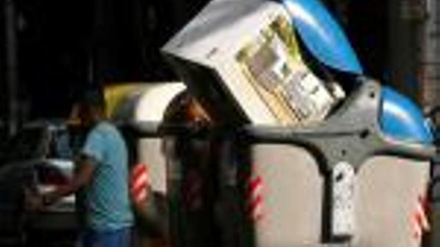 Una caixa de cartró obstruint un contenidor a la ciutat de Girona.