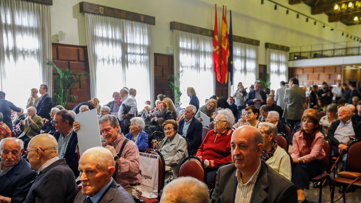Ancianos y ancianas cententarios, junto a sus familiares, este jueves en el Ayuntamiento de Zaragoza.