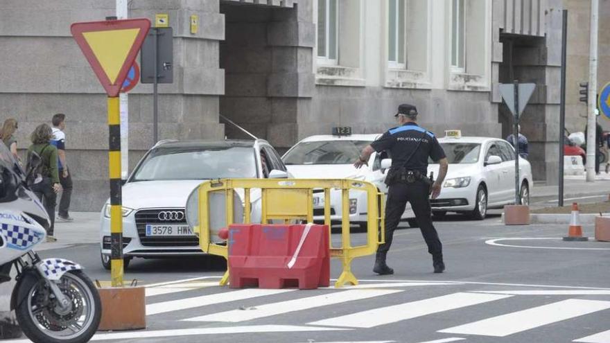 Un agente de la Policía Local multa a un motorista, ayer, a la altura de Correos.