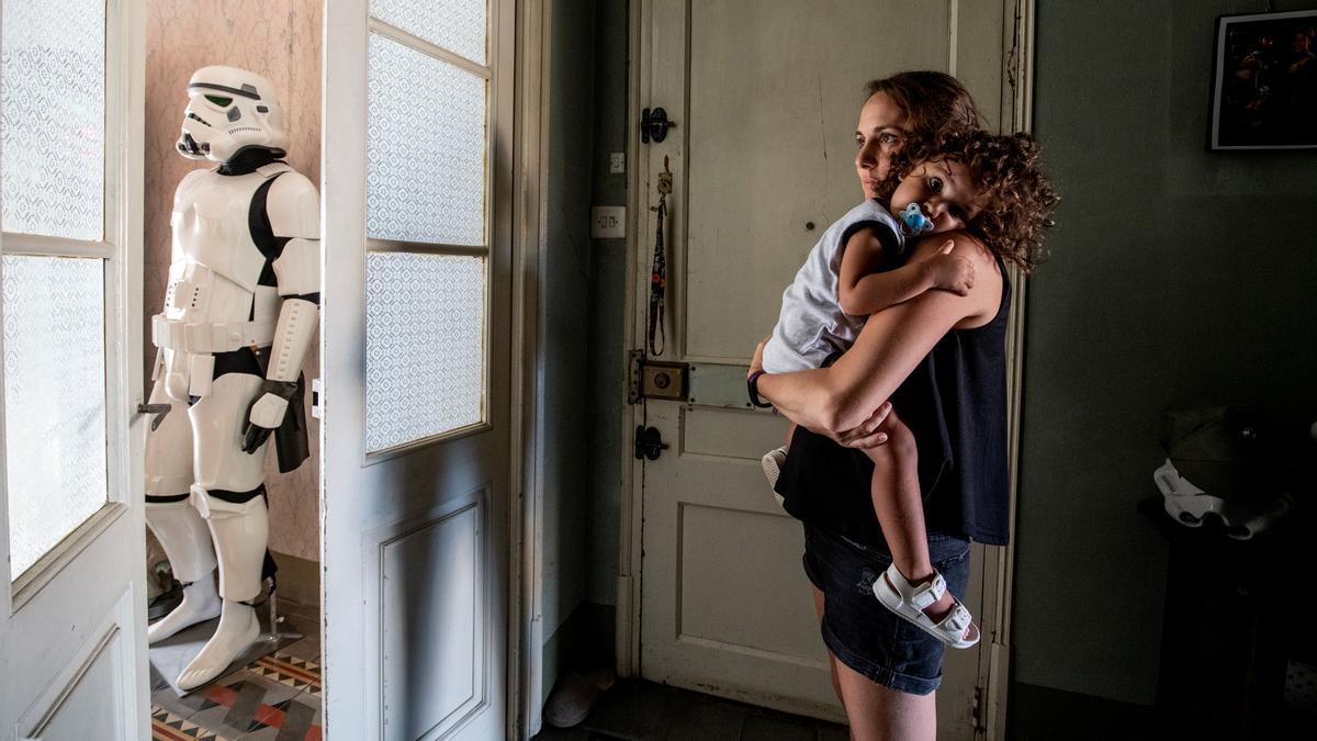 Xenia, con Ellen Connor en brazos, en la puerta de su casa con 'trooper' de fondo.