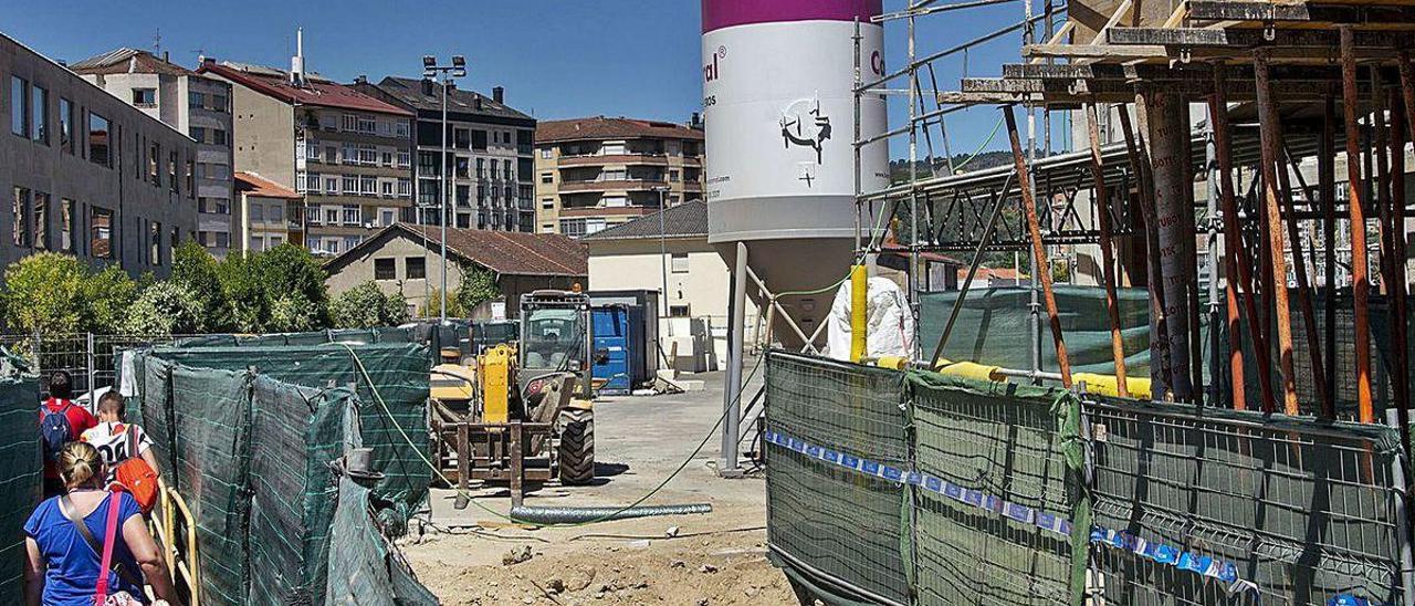 Viajeros del tren sorteando obstáculos por las obras de la nueva estación de bus.