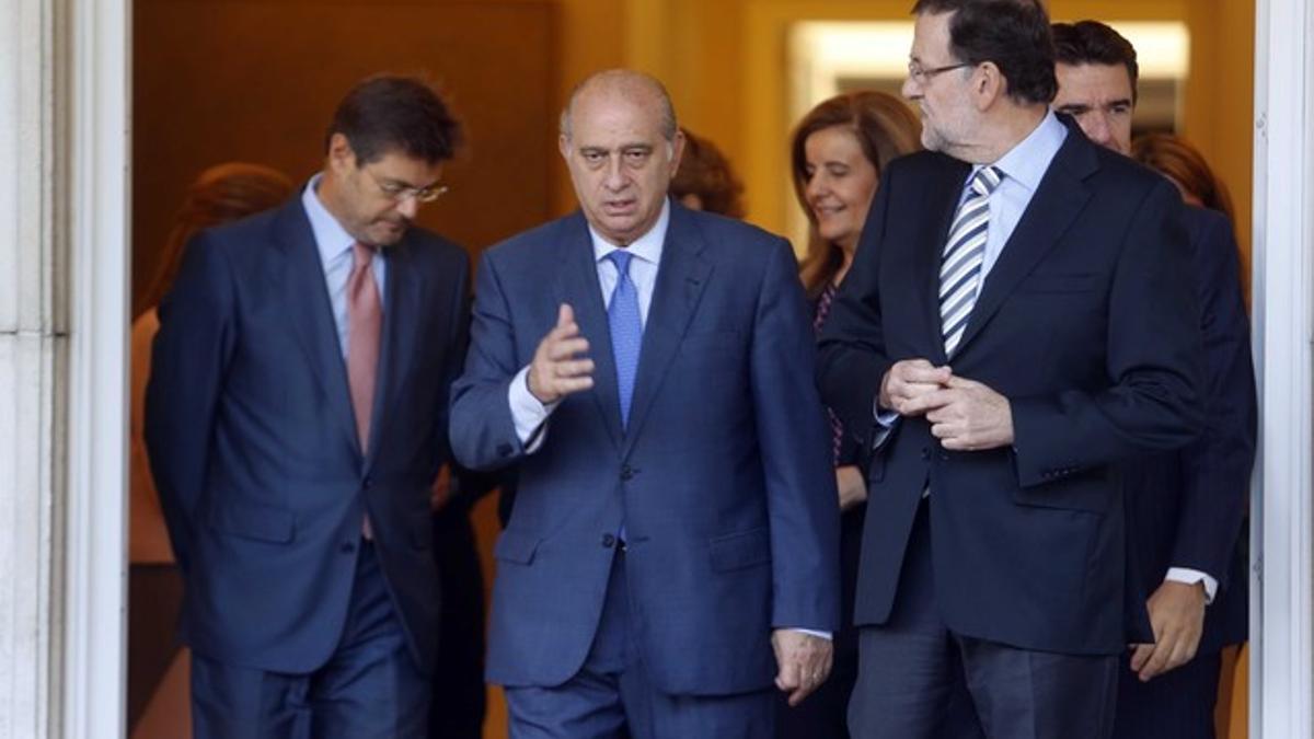 El ministro Jorge Fernández Díaz habla con Mariano Rajoy, a las puertas de la Moncloa, el pasado 3 de octubre.