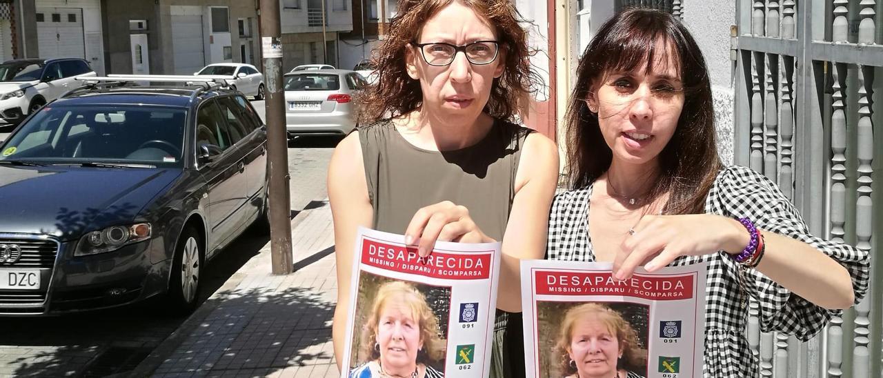 Las hijas de Manuela Barbosa, Ana y Raquel, muestran carteles con la foto de su madre, ayer, en Arcade
