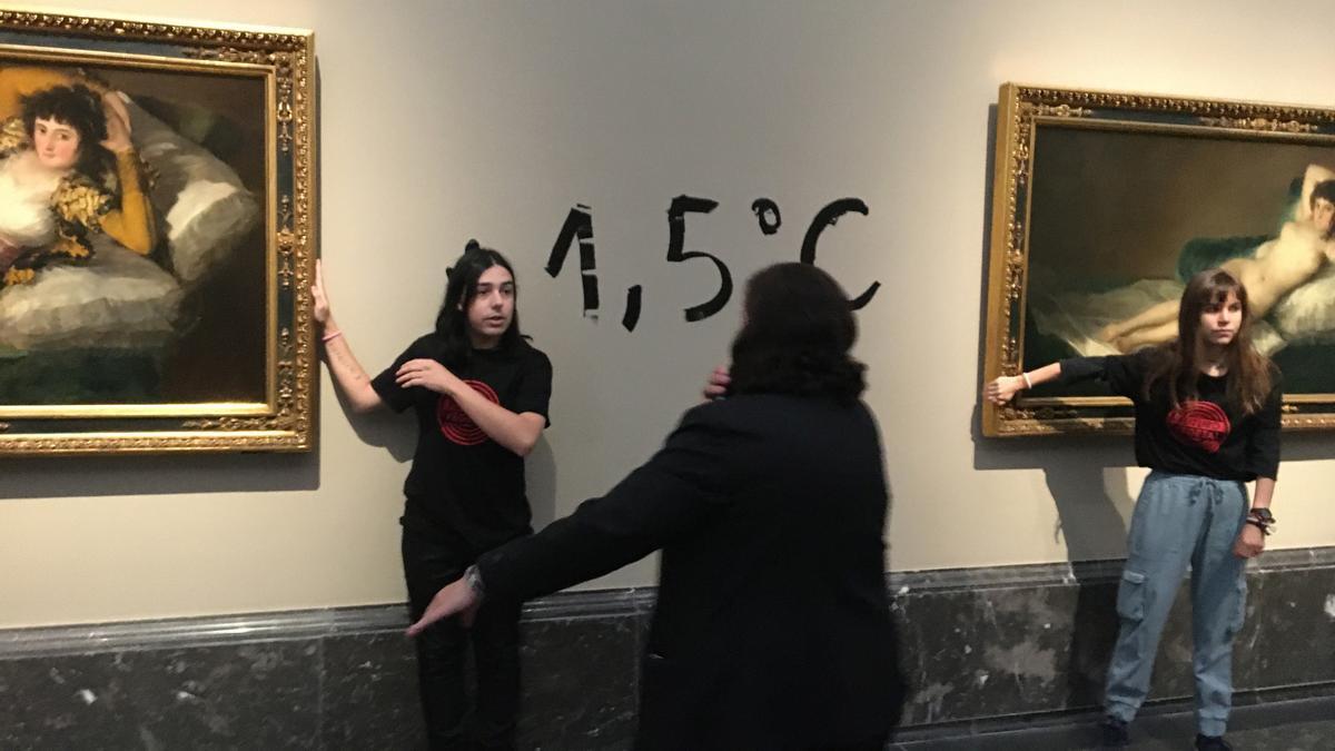 Activistas ecologistas se pegan al marco de 'La maja desnuda' y 'La maja vestida' de Francisco de Goya, en el Museo Nacional del Prado en Madrid.