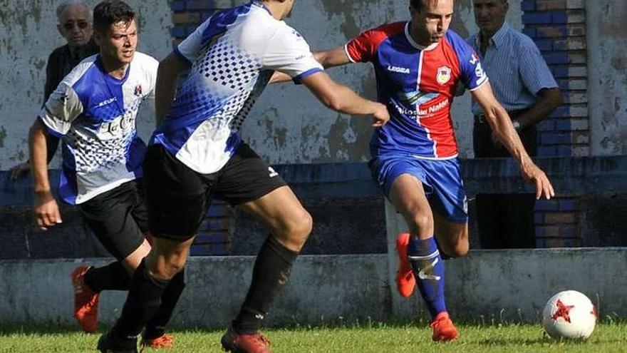 Aimar golpea el balón ante Jaime Serrano y Kike Fanjul.