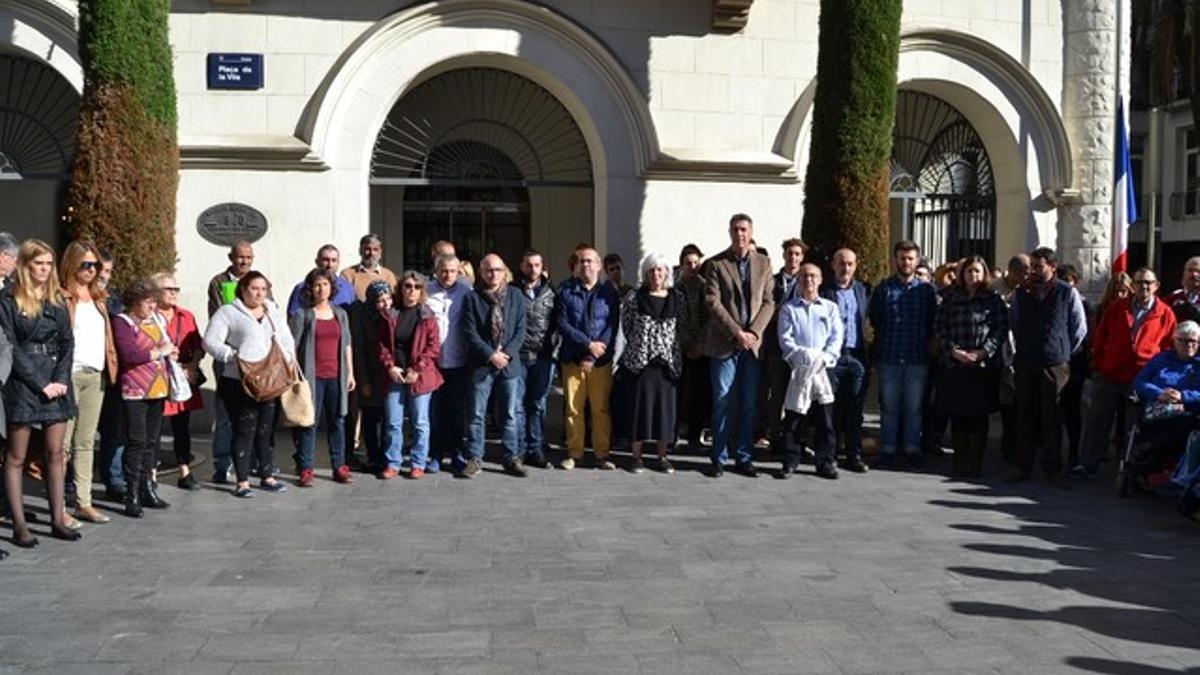 Representantes del Ayuntamiento y vecinos de Badalona durante el minuto de silencio en señal de duelo este lunes.